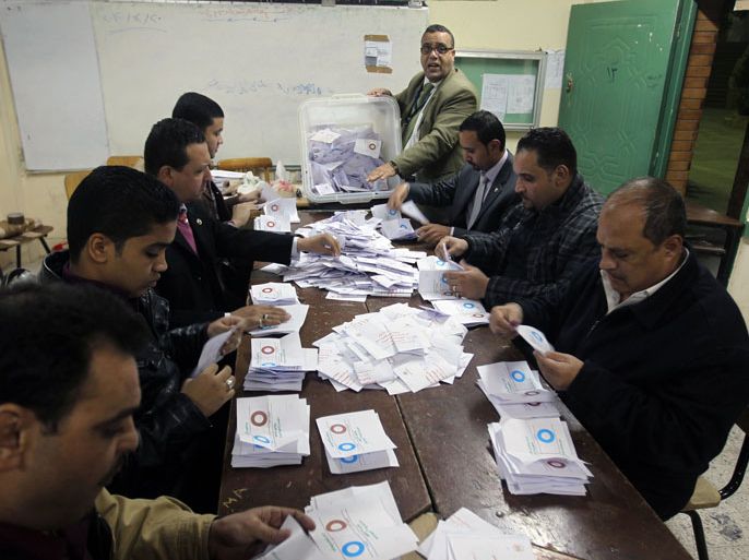 Polling station officials deposit ballots during the second round of a referendum on a new draft constitution in Giza, south of Cairo, on December 22, 2012. Egyptians are voting in the final round of a referendum on a new constitution championed by President Mohamed Morsi and his Islamist allies against fierce protests from the secular-leaning opposition