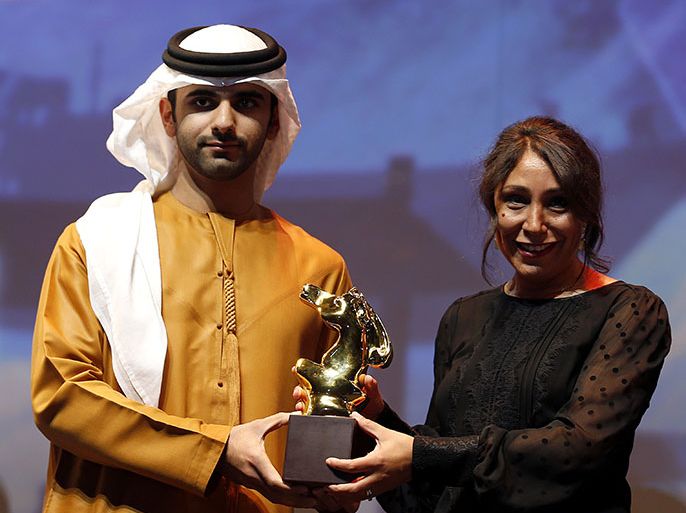 Saudi Arabian director Haifaa Al-Mansour (R) is presented by Sheikh Mansour, son of Dubai ruler Sheikh Mohammed bin Rashid al-Maktoum, with the award of Muhr Arab Feature award (Best film) for her film "Wadjda" during the at the Dubai International Film Festival in the Gulf emirate of Dubai on December 16, 2011. AFP PHOTO/KARIM SAHIB