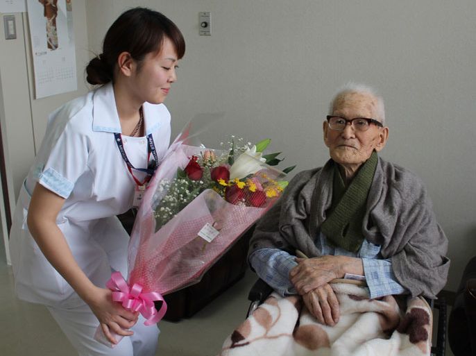 TOK1341 - Kyotango, Hyogo, JAPAN : This handout picture taken by the Kyotango City Government on December 26, 2012 shows 115-year-old man Jiroemon Kimura (R) receiving a flower bouquet