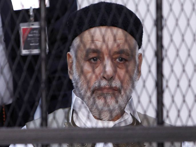 r : Baghdadi al-Mahmoudi, who was the last prime minister of Muammar Gaddafi's government, sits behind bars during the second hearing in his trial at a prison facility in Tripoli December 10, 2012. Mahmoudi is charged with corruption and ordering mass rape during the war that toppled the Libyan dictator. REUTERS/Ismail Zitouny (LIBYA - Tags: POLITICS CIVIL UNREST CRIME LAW)