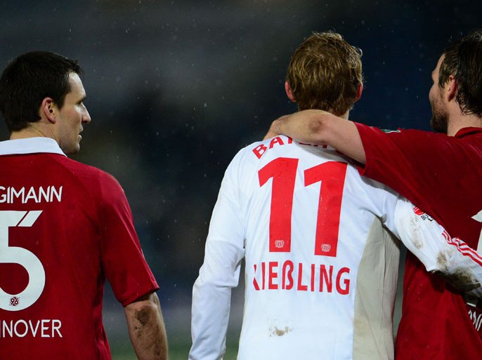 Hanover's Mario Eggimann (L) and Christian Schulz (R) and Leverkusen's Stefan Kiessling stand on the field after the German first division Bundesliga match between Hannover 96 and Bayer 04 Leverkusen at AWD-Arena in Hanover, eastern Germany, on December 9, 2012. AFP PHOTO / Peter Steffen /GERMANY