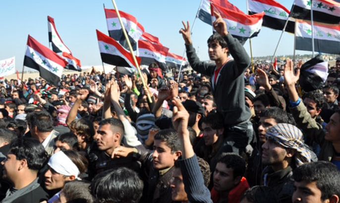 متظاهرون يرفعون الأعلام العراقية