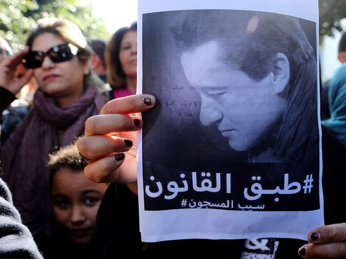 epa03515121 A Tunisian protester holds a poster depicting Sami Fehri during a demonstration on the outside of the Ministry of Justice to demand the liberation of Sami Fehri, TV producer and director of Ettounsiya Television, in Tunis, Tunisia,