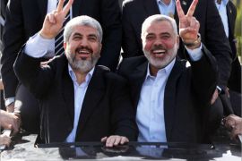 epa03500576 A handout picture provided by Prime Minister Haniyeh's office shows exiled Hamas leader Khaled Meshaal (L) and the Prime Minister of Gaza, Ismail Haniyeh, wave from the rooftop of a vehicle after Meshaal's arrival through the Egyptian-Gaza border in Rafah, 07 December 2012. Meshaal's first visit to the Gaza Strip comes just one day ahead of the 25th anniversary of Hamas. EPA/MOHAMMED AL OSTAZ HANDOUT EDITORIAL USE ONLY/NO SALES