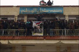 Free Syrian Army fighters from Al-Farooq battalion remove a poster of Syria's President Bashar Al-Assad from a military hospital after the fighters said they fought and defeated government troops in Halfaya, near Hama December 18, 2012. REUTERS/Samer Al-Hamwi/Shaam News Network/Handout (SYRIA - Tags: CONFLICT) FOR EDITORIAL USE ONLY. NOT FOR SALE FOR MARKETING OR ADVERTISING CAMPAIGNS. THIS IMAGE HAS BEEN SUPPLIED BY A THIRD PARTY. IT IS DISTRIBUTED, EXACTLY AS RECEIVED BY REUTERS, AS A SERVICE TO CLIENTS