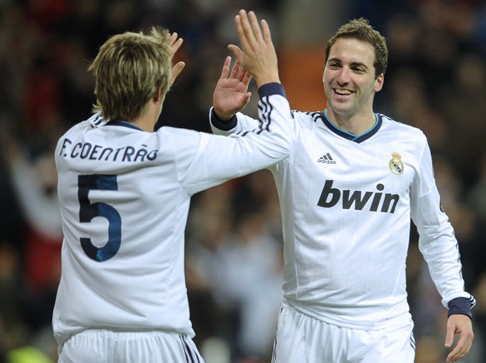 Real Madrid's Argentinian forward Gonzalo Higuain (R ) celebrate with Real Madrid's Portuguese defender Fabio Coentrao (L) during the Spanish Copa del Rey (King's Cup) quarter-final football match Real Madrid CF vs Valencia CF at the Santiago Bernabeu Stadium in Madrid on January 15, 2013. AFP PHOTO / PEDRO ARMESTRE