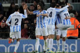 : Malaga's defender Sergio Sanchez (2ndL) celebrates after his teammate scored the equalizer goal during the Spanish Copa del Rey (King's Cup) quarter-final football match FC Barcelona vs Malaga CF at the Camp Nou stadium in Barcelona on January 16, 2013. The game ended in a draw 2