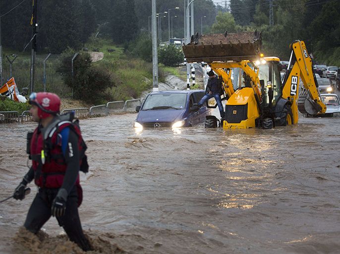 A rescue team evacuates people trapped in their cars in a flooded road near the Israeli-Arab town of Kfar Qara, in central Israel, on January 8, 2013. Stormy weather, including high winds and heavy rainfall, lashed Israel and the Palestinian territories, downing powerlines and trees and blocking roads causing several injuries. AFP PHOTO/MENAHEM KAHANA