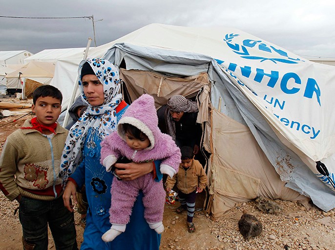 Syrian refugees leave their tents after heavy rain, at the Al-Zaatari refugee camp in the Jordanian city of Mafraq, near the border with Syria, January 8, 2013. REUTERS/Ali Jarekji (JORDAN - Tags: POLITICS CIVIL UNREST)