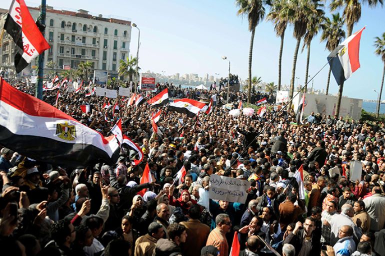 Egyptian demonstrator wave the national flag and shout slogans during a protest in Alexandria on January 25, 2013. Huge crowds are expected to demonstrate in Egypt on the second anniversary of the revolution that ousted Hosni Mubarak and brought in an Islamist government, as political tensions simmer and economic woes bite. AFP PHOTO/STR