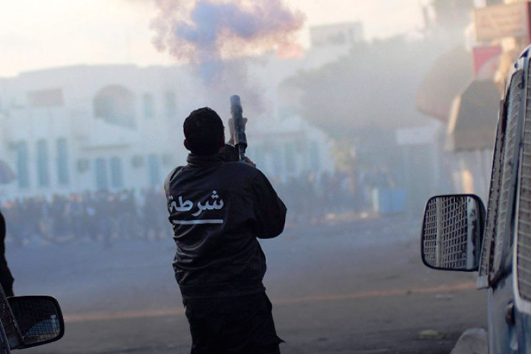 A police officer fires tear gas to break up a protest against the closure of the Ras Jdir border crossing with Libya in Ben Guerdane, southeast of Tunis January 8, 2013. REUTERS/Mohamed Amine ben Aziza (TUNISIA - Tags: POLITICS CIVIL UNREST)