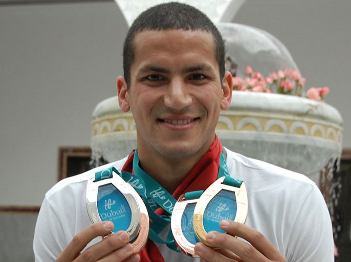 Oussama Mellouli of Tunisia poses with his four medals he won at the short course World Championship 2010 in Dubai upon his arrival in Tunis, at the Carthage Airport, Tunisia, on 22 December 2010, as he was received by Tunisian President Zine El Abidine Ben Ali (unseen). EPA/STR
