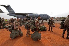 French soldiers carry their equipment after arriving on a US Air Force C-17 transport plane at the airport in Bamako January 22, 2013. The United States has started transporting French soldiers and equipment to Mali as part of its logistical aid to French forces fighting Islamist militants in the north of the country, a U.S. official said on Tuesday. REUTERS/Eric Gaillard (MALI - Tags: CIVIL UNREST CONFLICT MILITARY)