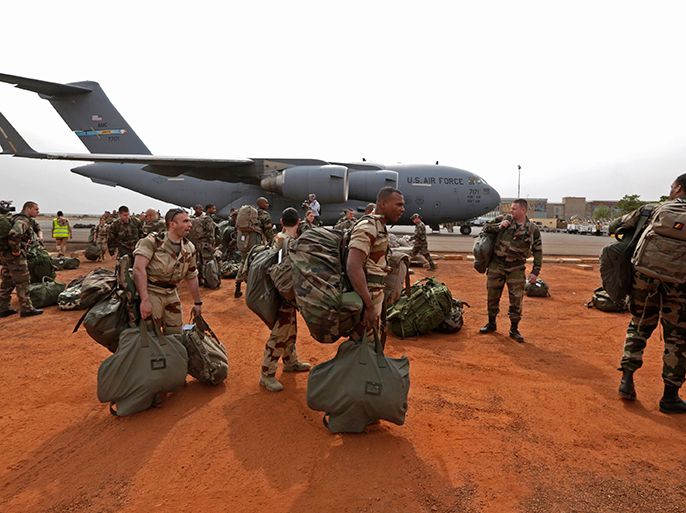 French soldiers carry their equipment after arriving on a US Air Force C-17 transport plane at the airport in Bamako January 22, 2013. The United States has started transporting French soldiers and equipment to Mali as part of its logistical aid to French forces fighting Islamist militants in the north of the country, a U.S. official said on Tuesday. REUTERS/Eric Gaillard (MALI - Tags: CIVIL UNREST CONFLICT MILITARY)