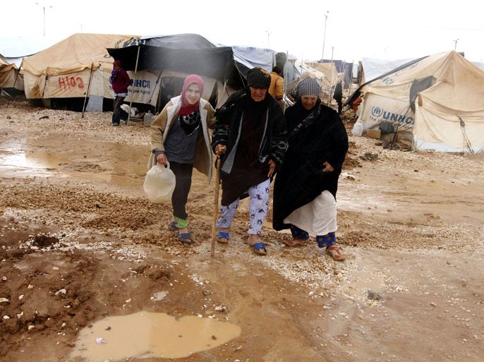 epa03529010 Syrian refugees walk in mud between tents at Zattari Syrian refugee camp, near city of Mafraq, Jordan, 09 January 2013. According to media reports, riots erupted on 08 January 2013 in the Zaatari Syrian refugee camp which was pounded by heavy rains for a second day, damaging 500 tents and submerging much of the site under one meter of mud. EPA/JAMAL NASRALLAH