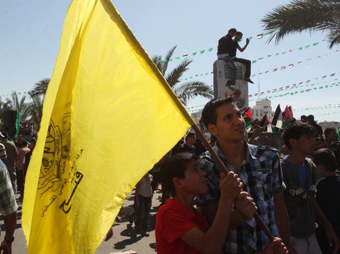 عنصر من فتح يحمل علم حركته في احتفال سابق بغزة