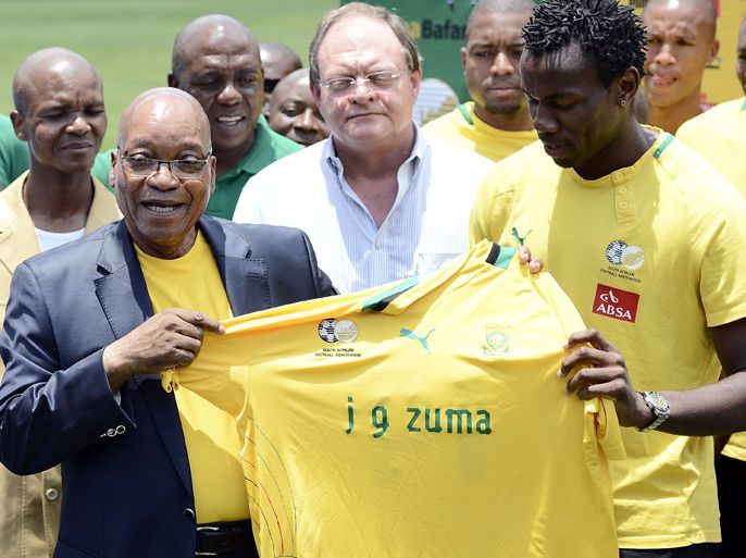 South Africa's President Jacob Zuma (L) receives a team jersey from the South African football team captain Bongani Khumalo (R) on January 15, 2013 at Orlando Stadium in Soweto. Zuma visited today the National Football Team, dubbed the Bafana Bafana at their training camp in Soweto to assure them of the nation's support ahead of the 2013 African Cup of Nations that will take place in South Africa from January 19 to February 10. AFP PHOTO / STEPHANE DE SAKUTIN