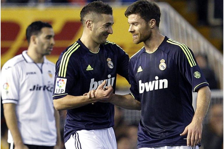 epa03552478 Real Madrid's Karim Benzema (L) celebrates with Xabi Alonso (C) after scoring the opening goal against Valencia CF during the King's Cup quarter finals second leg soccer match between Valencia and Real Madrid at the Mestalla stadium in Valencia, Spain, 23 January 2013. EPA/JUAN CARLOS CARDENAS