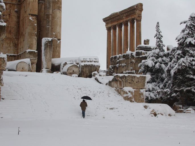 A visitor climbs the steps of Baalbek's Bachus temple as snow covers the Roman ruins of the historic town in eastern Lebanon's Bekaa Valley on January 9, 2013, following a fierce storm which has whipped the region this week with temperatures dropping dramatically and snow falling on low levels across Lebanon, Syria, Jordan