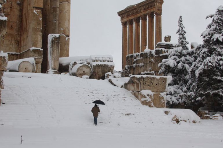 A visitor climbs the steps of Baalbek's Bachus temple as snow covers the Roman ruins of the historic town in eastern Lebanon's Bekaa Valley on January 9, 2013, following a fierce storm which has whipped the region this week with temperatures dropping dramatically and snow falling on low levels across Lebanon, Syria, Jordan