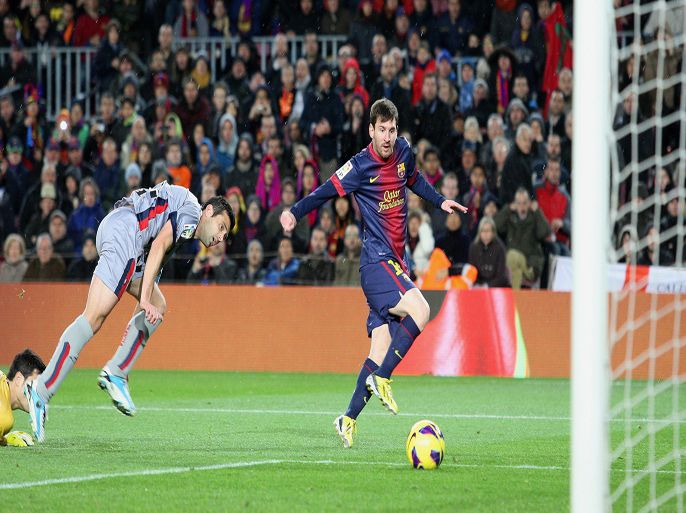 QG009 - Barcelona, -, SPAIN : Barcelona's Argentinian forward Lionel Messi (R) scores during the Spanish league football match FC Barcelona vs C.A. Osasuna at the Camp Nou stadium in Barcelona on January 27, 2013. AFP PHOTO