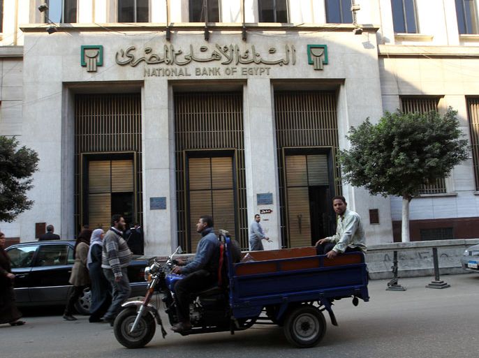 epa03520975 An exterior view shows the National Bank of Egypt, in Cairo, Egypt, 31 December 2012. Reports state Egyptian President Mohamed Morsi said on 30 December, the market will stabilize within days after the Egyptian pound has declined against the dollar, and that the government has moved towards balancing the market. Recently Credit-rating agency Standard & Poor's cut Egypt's long-term rating to B-. Egypt is still waiting for a the upcoming IMF loan of 4.8 Billion Dollars. EPA/KHALED ELFIQI