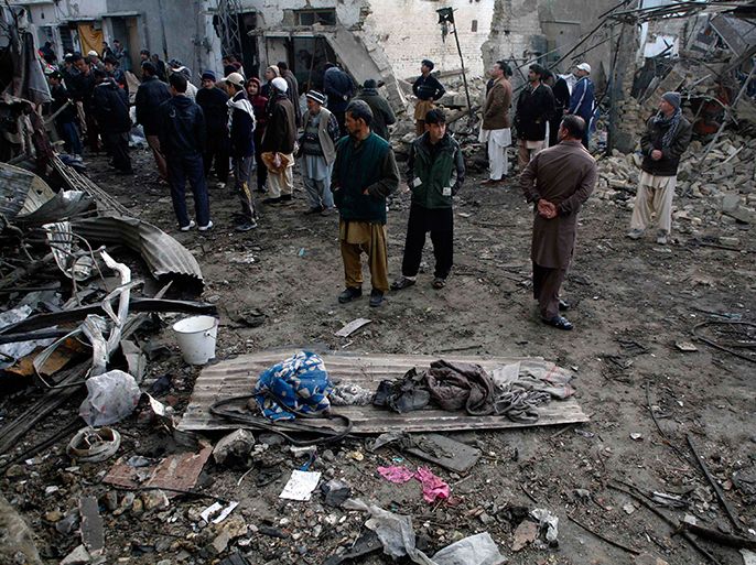 People inspect the site of yesterday's bomb blast in Quetta January 11, 2013. The death toll from a series of bombings in two Pakistani cities on Thursday, one of the bloodiest days in the country's history, has reached 114, police said Friday. REUTERS/Naseer Ahmed (PAKISTAN - Tags: CIVIL UNREST POLITICS)