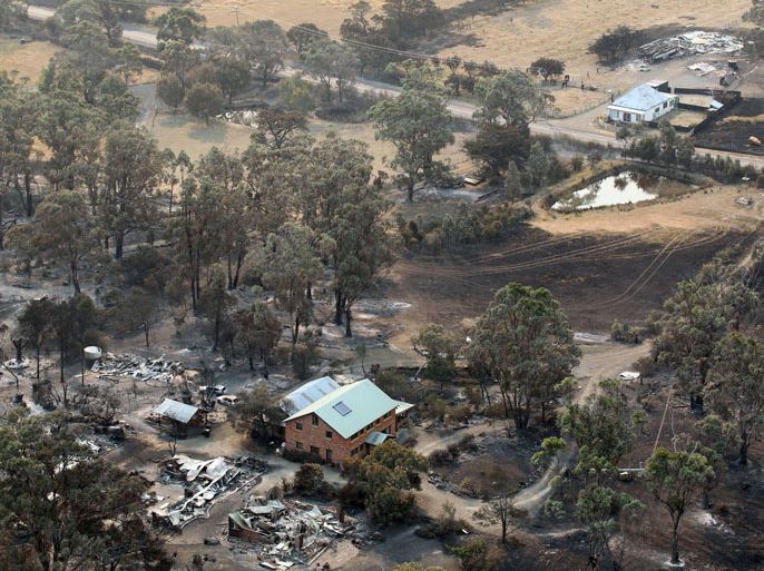 AD106 - Dunalley, Tasmania, AUSTRALIA : This aerial photograph taken on January 5, 2013 shows the devastated town of Dunalley after bush fires swept through the area. Thousands of people have fled wildfires raging on the Australian island of Tasmania that have destroyed at least 80 properties amid fears that at least one man died in the blaze, police said