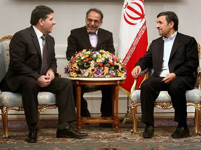 Iranian President Mahmoud Ahmadinejad (R) greets Syrian Prime Minister Wael al-Halaqi (L) prior to a meeting in Tehran on January 15, 2013. Fars news agency said the two sides will discuss "expansion of bilateral relations and Syrian President Bashar al-Assad's three-step plan" for the political future, presented on January 6. AFP PHOTO/BEHROUZ MEHRI