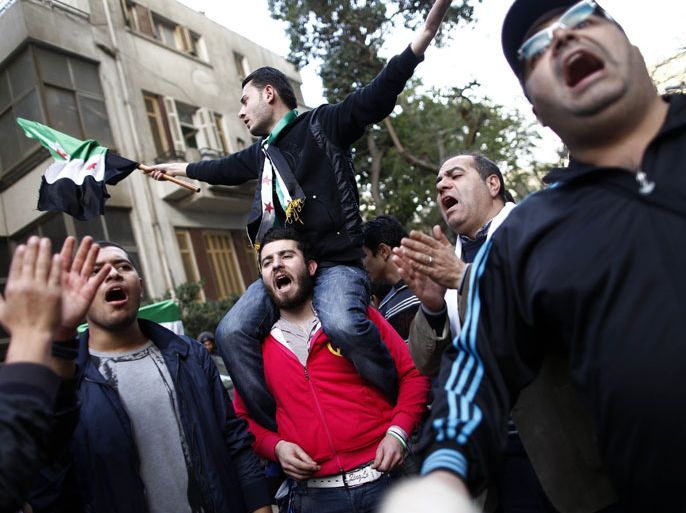 EGY1989 - Cairo, -, EGYPT : Protesters wave the pre-Baath Syrian flag, now used by the Free Syrian Army, as they shout slogans against the Syrian and Iranian regimes during a demonstration outside the Iranian embassy in the Egyptian capital Cairo on February 6, 2013. Egyptian President Mohamed Morsi urged Syrian opposition groups to unify, as he addressed leaders of Islamic states at a summit of the Organisation of Islamic Cooperation in Cairo. Iran is the chief regional backer of Syrian President Bashar al-Assad, while Egypt and Gulf powerhouse Saudi Arabia bitterly oppose Assad and support rebels seeking his ouster. AFP PHOTO/MAHMUD KHALED