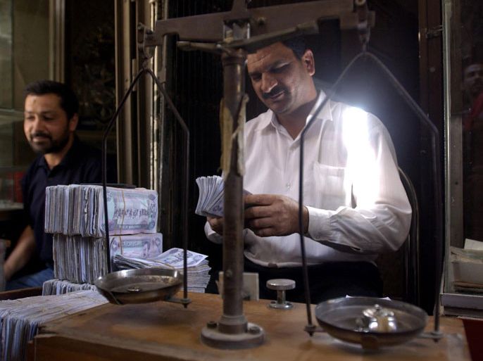 A dealer counts money at an exchange booth on Sunday, 04 May 2003, downtown Baghdad. The Iraqi dinar was back at pre-war levels as Iraqis began selling dollars to buy supplies, encouraged that life is returning to normal and by hope that the United Nations will soon lift crippling sanctions. EPA PHOTO DPA/MARCEL METTELSIEFEN