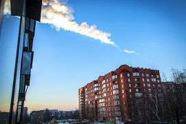 The trail of a falling object is seen above a residential apartment block in the Urals city of Chelyabinsk, on February 15, 2013