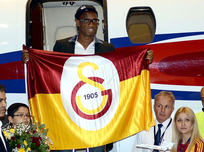 epa03574027 Striker Didier Drogba from the Ivory Coast holds a club flag of Turkish Super League side Galatasaray Istanbul upon his arrival at Ataturk Airport in Istanbul, Turkey, 08 February 2013. EPA/BERK OZKAN - ANADOLU AGENCY TURKEY OUT EDITORIAL USE ONLY/NO SALES/NO ARCHIVES
