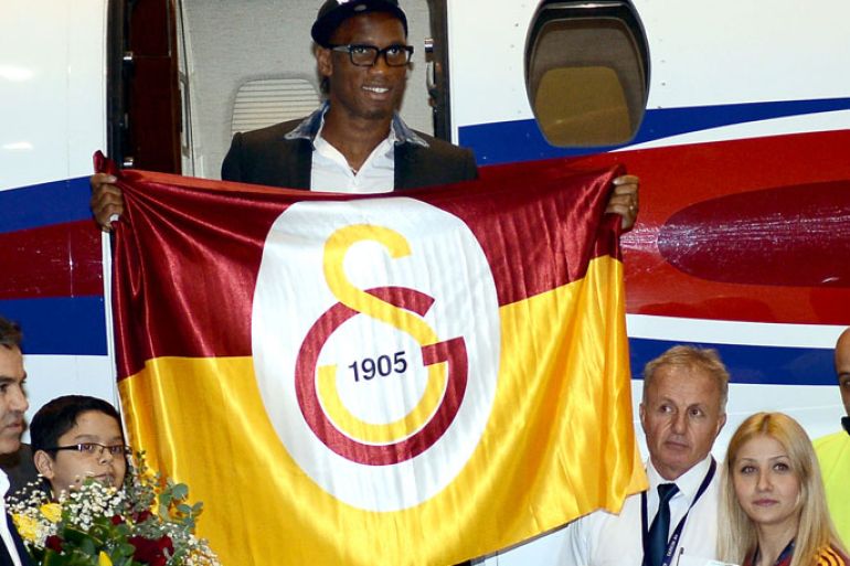 epa03574027 Striker Didier Drogba from the Ivory Coast holds a club flag of Turkish Super League side Galatasaray Istanbul upon his arrival at Ataturk Airport in Istanbul, Turkey, 08 February 2013. EPA/BERK OZKAN - ANADOLU AGENCY TURKEY OUT EDITORIAL USE ONLY/NO SALES/NO ARCHIVES
