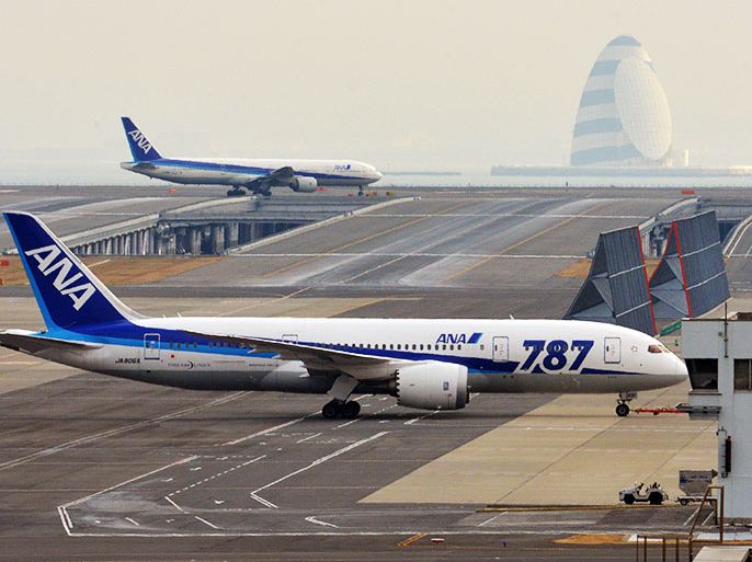 (FILES) This file picture taken on January 16, 2013 shows an All Nippon Airways' (ANA) Boeing 787 Dreamliner (bottom) being pulled by a towing tractor at Tokyo's Haneda airport after a ANA Dreamliner passenger plane made an emergency landing in western Japan when smoke was reportedly seen inside the cockpit. ANA said on February 7, 2013 it would cancel 681 flights in March, bringing the number of flights scrapped due to the Boeing Dreamliner's grounding last month to nearly 1,900. AFP PHOTO / FILES / Yoshikazu TSUNO