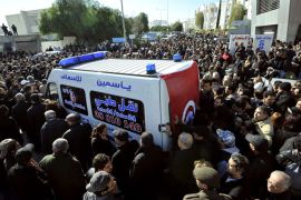 People surround an ambulance transporting the body of Tunisian opposition leader and outspoken government critic Chokri Belaid, from from a clinic in Tunis to the public hospital for an autopsy, after he was shot dead with three bullets fired from close range, on February 6, 2013. Tunisian Premier Hamadi Jebali called the assassination "an act of terrorism", as the country grapples with growing political instability. AFP PHOTO / FETHI BELAID