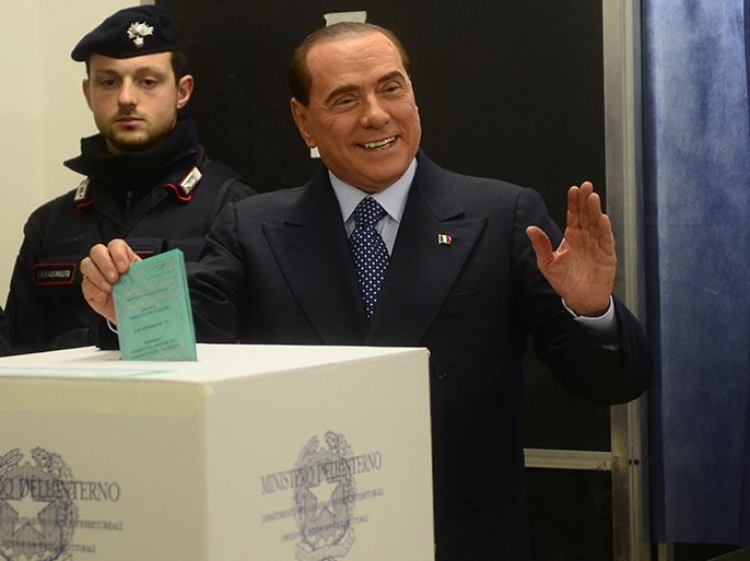 Italian former Prime Minister Silvio Berlusconi casts his ballot at a polling station on February 24, 2013 in Milan. Italians fed up with austerity went to the polls on Sunday in elections where the centre-left is the favourite, as Europe held its breath for signs of fresh instability in the eurozone's third economy. AFP PHOTO / OLIVIER MORIN