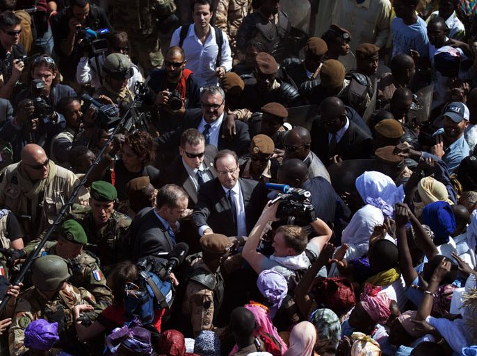 France's President Francois Hollande (C) is welcomed by Malian people as he arrives at Timbuktu, the second step of his one-day visit in Mali, on February 2, 2013. Hollande visits Mali as French-led troops work to secure the last Islamist stronghold in the north after a lightning offensive against the extremists. AFP PHOTO FRED DUFOUR