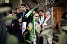 Syrian opposition figures hold former Syrian national flags as they stage a sit-in protest outside the Arab League headquarters in Cairo on February 23, 2013. The opposition National Coalition said on February 22, it will form a government to run "liberated areas" of Syria, as monitors said more than 12 people were killed when buildings collapsed in a missile strike on the city of Aleppo. AFP PHOTO/GIANLUIGI GUERCIA