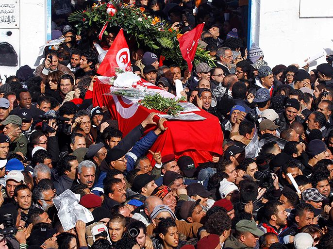 Mourners carry the coffin of slain opposition leader Chokri Belaid during his funeral procession towards the nearby cemetery of El-Jellaz, where he is to be buried, in the Jebel Jelloud district of Tunis February 8, 2013. Tens of thousands of mourners chanted anti-Islamist slogans on Friday at the Tunis funeral of secular opposition leader Belaid, whose assassination has plunged Tunisia deeper into political crisis. REUTERS/Anis Mili (TUNISIA - Tags: POLITICS CIVIL UNREST CRIME LAW TPX IMAGES OF THE DAY)