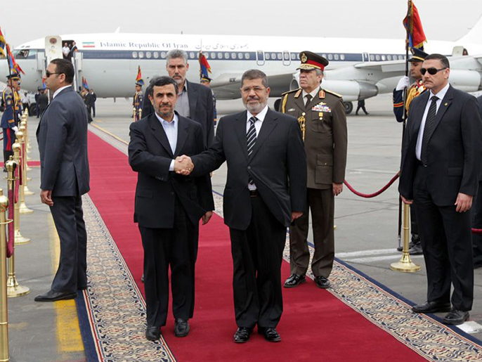 ‪محمد مرسي أثناء استقباله أحمدي نجاد‬ (الفرنسية)