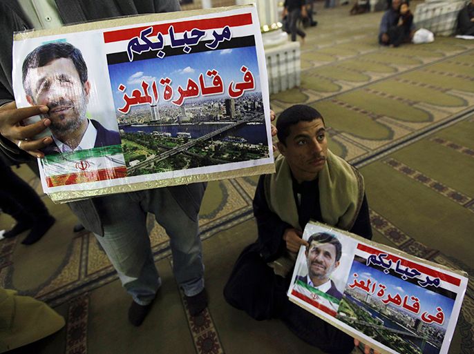 People hold posters with an image of Iran's President Mahmoud Ahmadinejad at the Al-Hussein mosque, named after Prophet Mohammed's grandson Hussein ibn Ali, before Ahmadinejad's visit to the mosque in old Cairo February 5, 2013. Ahmadinejad was both kissed and scolded on Tuesday when he began the first visit to Egypt by an Iranian president since Tehran's 1979 Islamic revolution. The trip was meant to underline a thaw in relations since Egyptians elected an Islamist head of state, President Mohamed Mursi, last June. But it also highlighted deep theological and geopolitical differences. The signs read, "Welcome in great Cairo" REUTERS/Amr Abdallah Dalsh (EGYPT - Tags: POLITICS RELIGION CIVIL UNREST)