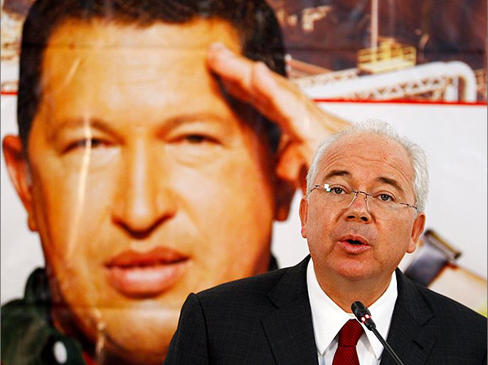 Venezuela's Energy Minister Rafael Ramirez talks to the media in front of a giant picture of Venezuela's President Hugo Chavez during a news conference at the headquarters of the state-run oil company PDVSA in Caracas February 13, 2013. REUTERS/Carlos Garcia Rawlins (VENEZUELA - Tags: POLITICS ENERGY)