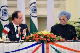 French President Francois Hollande (L) claps at the end of Indian Prime Minister Manmohan Singh's speech after members of their delegation signed several bilateral agreements in New Delhi on February 14, 2013. French President Francois Hollande embarked on a fresh push to clinch a USD 12-billion sale of Rafale fighter jets as he held talks in India on his first visit to Asia since taking office. The Socialist president was accompanied by a high-powered delegation of five ministers including Foreign Minister Laurent Fabius and Defence Minister Jean-Yves Le Drian and the chiefs of more than 60 top French companies