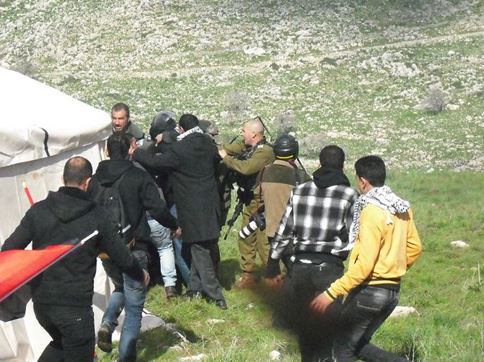 الشبان الفلسطينيون يخلصون احد زملائهم الذي اعتقله جنود الاحتلال اثناء المواجهات- الجزيرة نت