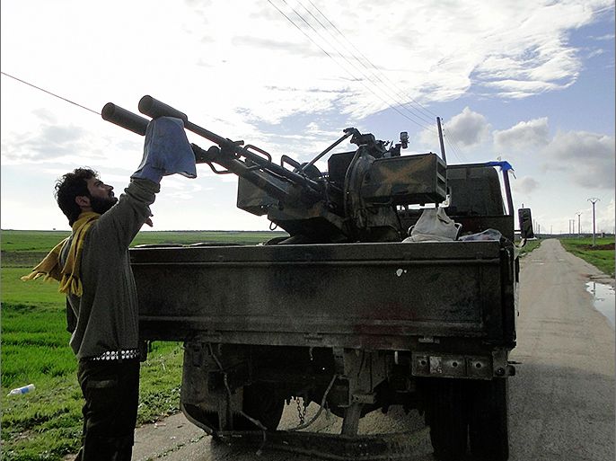 A Free Syrian Army fighter cleans an anti-aircraft artillery gun near the Menagh military airport in Aleppo's countryside February 17, 2013. REUTERS/Mahmoud Hassano (SYRIA - Tags: CONFLICT POLITICS CIVIL UNREST)
