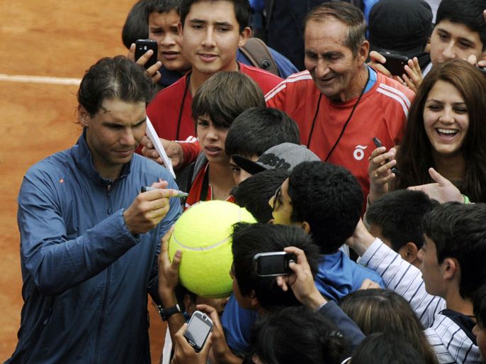Spanish tennis player Rafael Nadal signs autographs before a training session in Vina del Mar, about 120 km west of Santiago,Chile, on February 4 ,2013. Nadal, an 11-time Grand Slam winner, is preparing to take part in the ATP event in Vina del Mar. Nadal returns to competitive tennis after seven months on the sidelines due to a knee injury. AFP PHOTO/RAUL ZAMORA