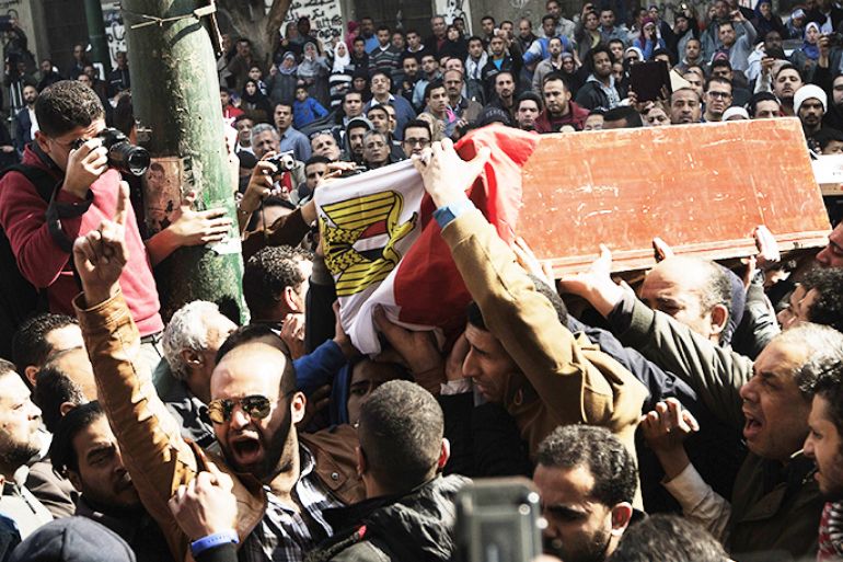 Mourners carry the coffins of killed Egyptian activists Amro Saad and Mohammed al-Guindi during their funeral outside Omar Makram Mosque in Cairo's Tahrir Square on February 4, 2013. Saad died in clashes during anti-government protests on February 1, while Guindi, 28, went missing last month after joining protests demanding change on the second anniversary of Egypt's uprising against former president Hosni Mubarak and then slipped into a coma following days in police custody, according to the health ministry and his party. AFP PHOTO/GIANLUIGI GUERCIA