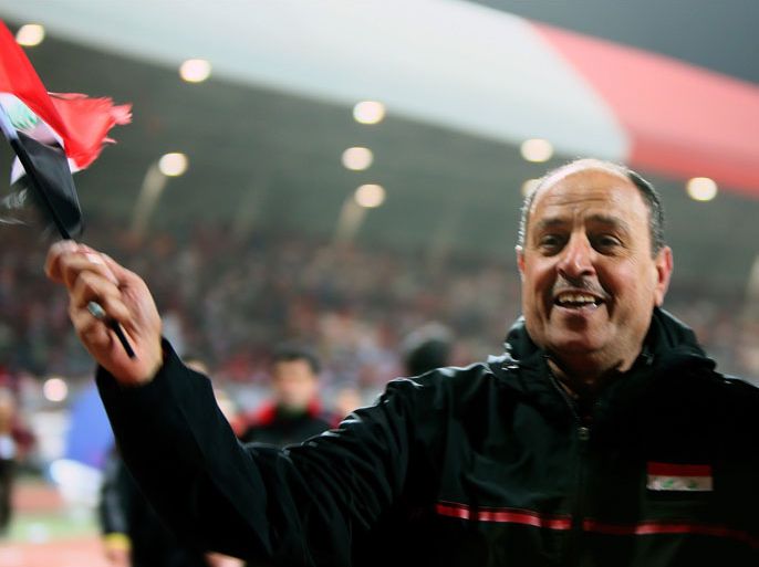 i coach Hakim Shaker (C) waves his country's national flag after his team won the semi final match against Bahrain in penalty shoot-out during the 21st Gulf Cup in Manama, on January 15, 2013. Iraq will meet United Arab Emirates in the final.