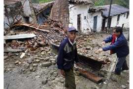 Colombian Victor Manuel Gutierrez (L) stands next to his destroyed house in Quetame village, Cundinamarca department, Colombia on May 25, 2008, after an earthquake